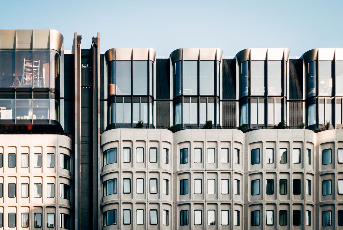 A curved modernist office façade of glass and pale stone
